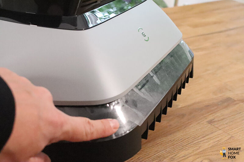 Die Stoßdämpfer des ECOVACS Goat G1-800 ist in der Nahaufnahme zu sehen und wird mit der Hand gedrückt.